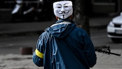 Ein Mitglied der ukrainischen Streitkräfte patrouilliert mit der als Markenzeichen von Anonymous bekannten Guy-Fawkes-Maske durch die Innenstadt von Kiew. (Bild: AFP)