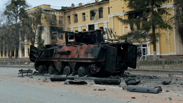 Zerstörung durch den „Sondereinsatz“ der Russen: Ein Panzer der Ukrainer vor einer bombardierten Schule in der Nähe des Stadtzentrums von Charkiw (Bild: AFP)