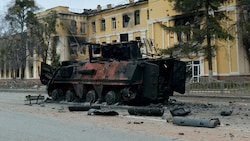 Zerstörung durch den „Sondereinsatz“ der Russen: Ein Panzer der Ukrainer vor einer bombardierten Schule in der Nähe des Stadtzentrums von Charkiw (Bild: AFP)