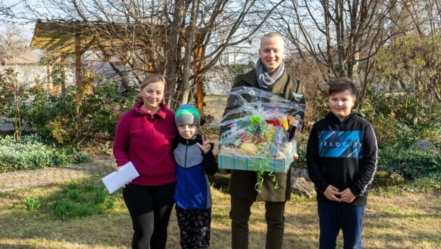 Oksana und ihre Söhne Maxi und Daniel mit Nationalrat Maximilian Köllner. Er überbrachte der Familie einen Geschenkskorb und Gutscheine, die sie in der Gemeinde einlösen können. (Bild: Charlotte Titz)