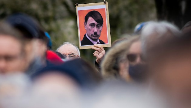 Demo in Nantes (Frankreich): Ein Plakat, das den russischen Staatschef Wladimir Putin in der Verkleidung von Adolf Hitler zeigt. (Bild: AFP)