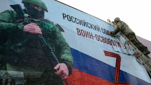 „Ein russischer Soldat ist ein Befreier“, plakatiert Russland auf der Krim - nun sollen auch syrische Soldaten aushelfen. (Bild: AFP/STRINGER)