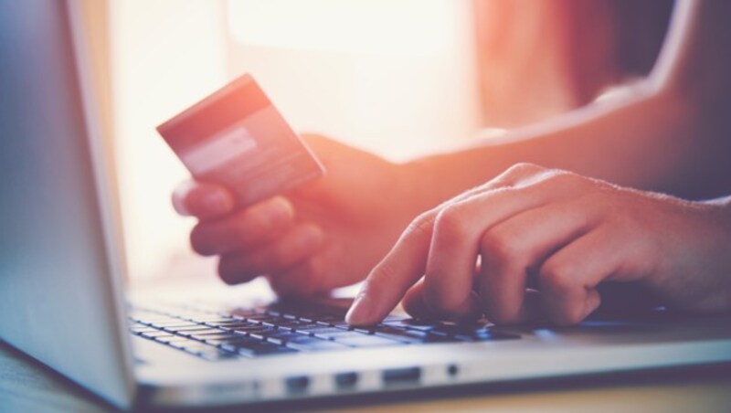 Hands holding credit card and using laptop. Online shopping (Bild: Ivan Kruk)