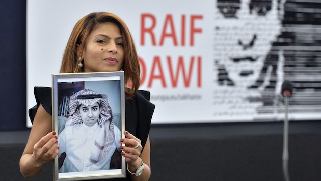 Ehefrau Ensaf Haidar mit einem Foto ihres Ehemanns Raif Badawi auf einem Archivbild aus dem Dezember 2015 (Bild: AFP/Patrick Hertzog)