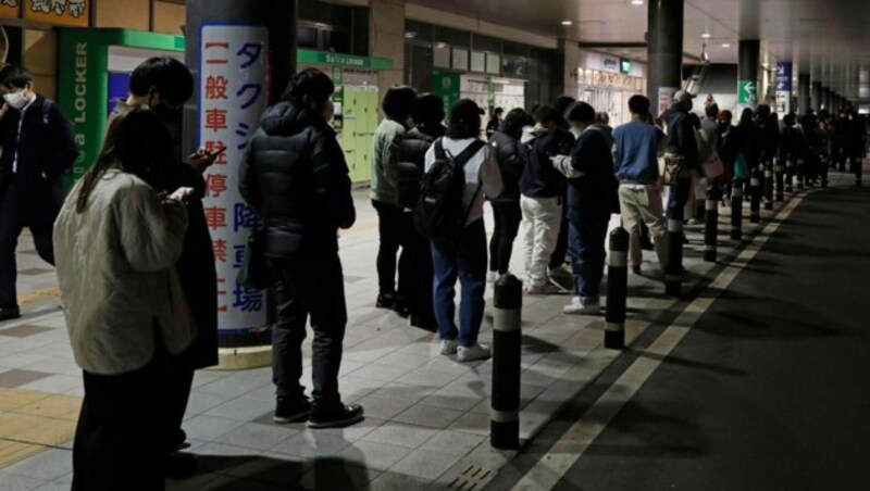 Menschen stellen sich in Sendai in der Präfektur Miyagi nach dem Erdbeben in einer Schlange an, um auf ein Taxi zu warten. (Bild: AP)