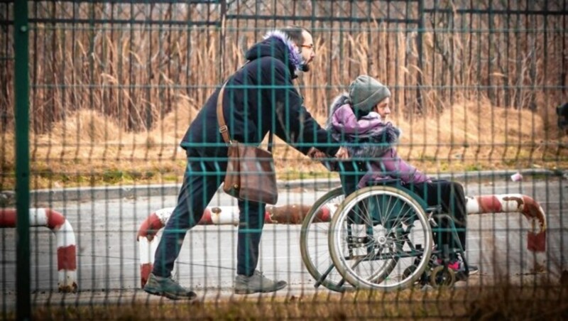 Ein Vater schiebt sein Kind der Grenze entgegen. (Bild: Sepp Pail)