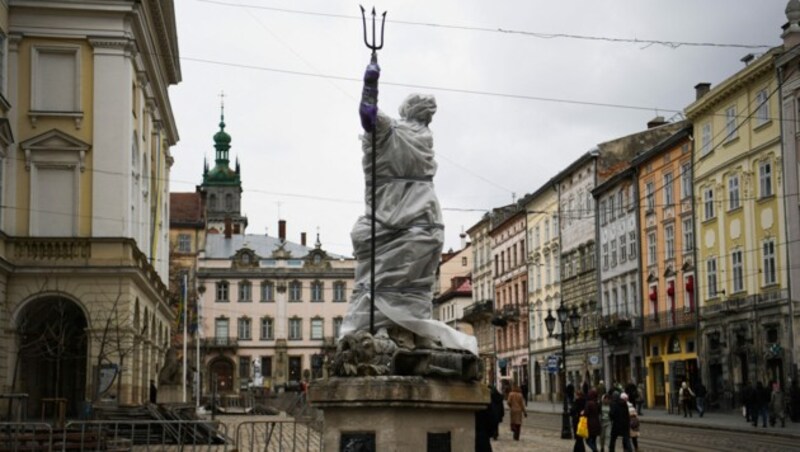 Die Neptunstatue in Lemberg wurde in Planen eingewickelt, um sie vor Angriffen zu schützen. (Bild: AFP)