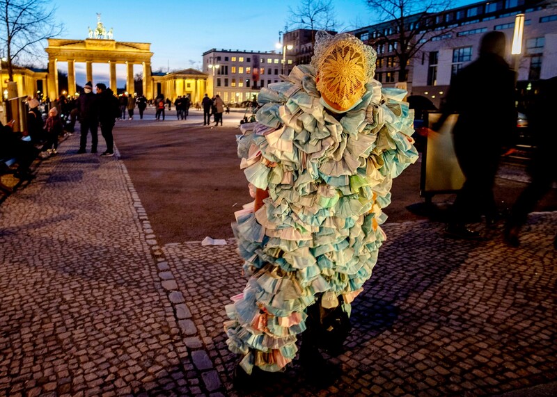 Eine Frau auf einer Corona-Demo in Berlin in einem Kostüm, das aus Gesichtsmasken gefertigt wurde. (Bild: AP Photo/Michael Probst,file)