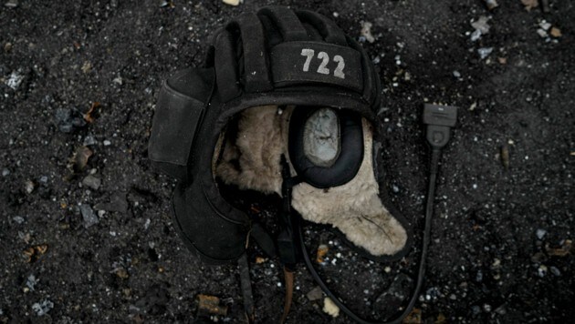 Die Kopfbedeckung eines Panzerfahrers liegt auf dem Boden neben einem zerstörten russischen Panzer. (Bild: The Associated Press)