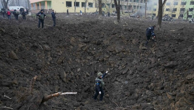 Soldaten und Rettungskräfte nach Bombardements in Mariupol (Bild: AP)