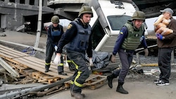 Ukrainische Soldaten bergen die Leiche eines Zivilisten in Kiew (Bild: AP)