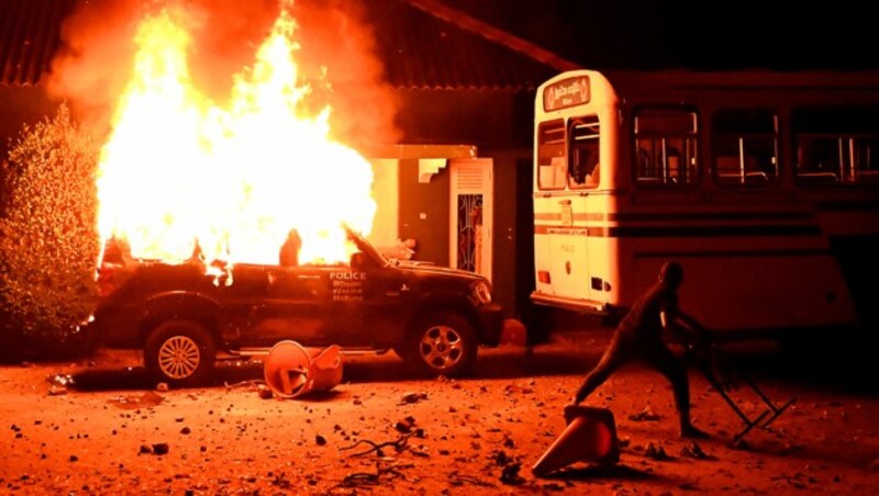 Dieses Polizeifahrzeug brannte komplett aus. (Bild: APA/AFP/Ishara S. KODIKARA)