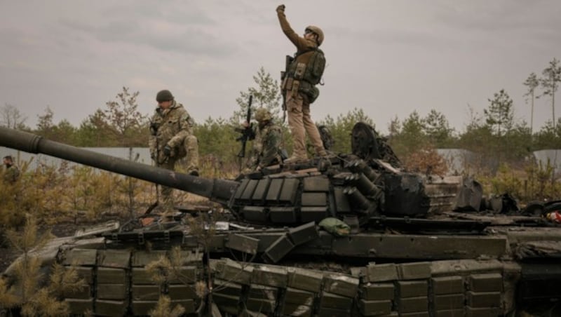 Ukrainische Soldaten auf einem zerstörten russischen Panzer (Bild: AP)