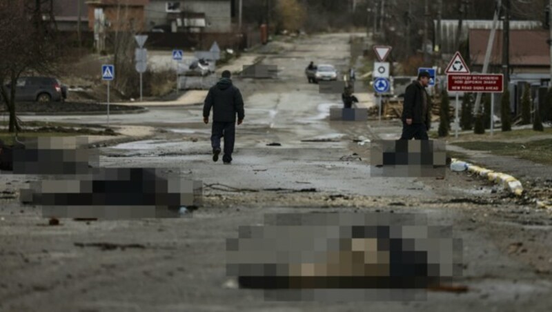 AFP-Reporter berichten von mindestens 20 Leichen von Männern in Zivilkleidung alleine in dieser Straße. (Bild: AFP/RONALDO SCHEMIDT, Krone KREATIV)