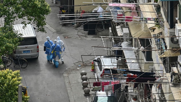 In normalerweise stark frequentierten Straßen ist aktuell nur Gesundheitspersonal unterwegs - die Bilder aus Shanghai erinnern an den Beginn der Pandemie. (Bild: AFP/Hector RETAMAL)