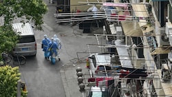In normalerweise stark frequentierten Straßen ist aktuell nur Gesundheitspersonal unterwegs - die Bilder aus Shanghai erinnern an den Beginn der Pandemie. (Bild: AFP/Hector RETAMAL)