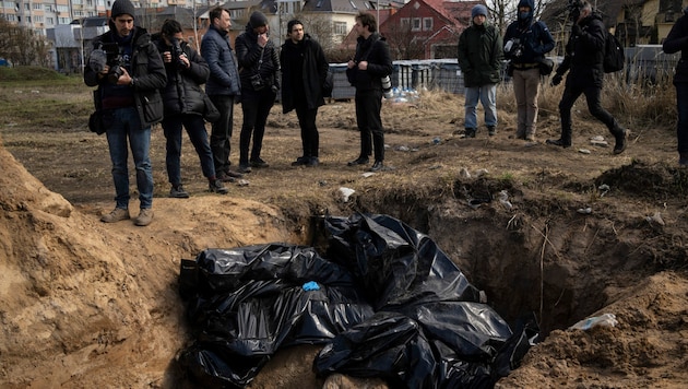 April 2022: Journalisten stehen in Butscha vor einem Massengrab. (Bild: Associated Press)