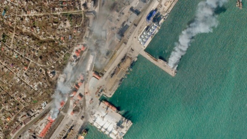 Auf diesem Satellitenfoto von Planet Labs PBC brennen ein ukrainisches Marineschiff und ein nahe gelegenes Gebäude in der belagerten Stadt Mariupol. (Bild: AP)