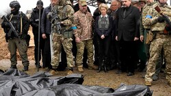 EU-Kommissionspräsidentin Ursula von der Leyen und EU-Außenbeauftragtem Josep Borrell (hinter von der Leyen) werden einige der Opfer von Butscha gezeigt. (Bild: AP)