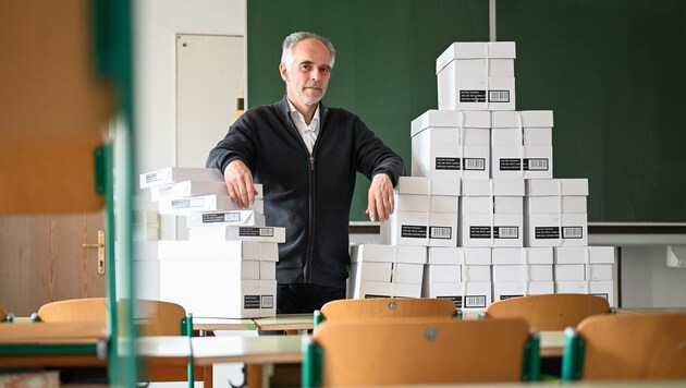 Direktor Wolfgang Waxenegger vor seinem Papierberg. 800 Kartons stapeln sich seit der Vorwoche in seiner Schule. (Bild: Alexander Schwarzl)