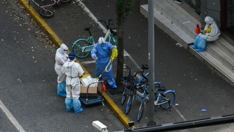 Schutzkleidung ist in Shanghai wieder überall zu sehen. (Bild: AFP)