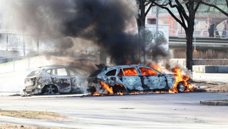 Zwei Autos wurden bei Ausschreitungen in Norrkoping in Brand gesetzt. (Bild: AP)