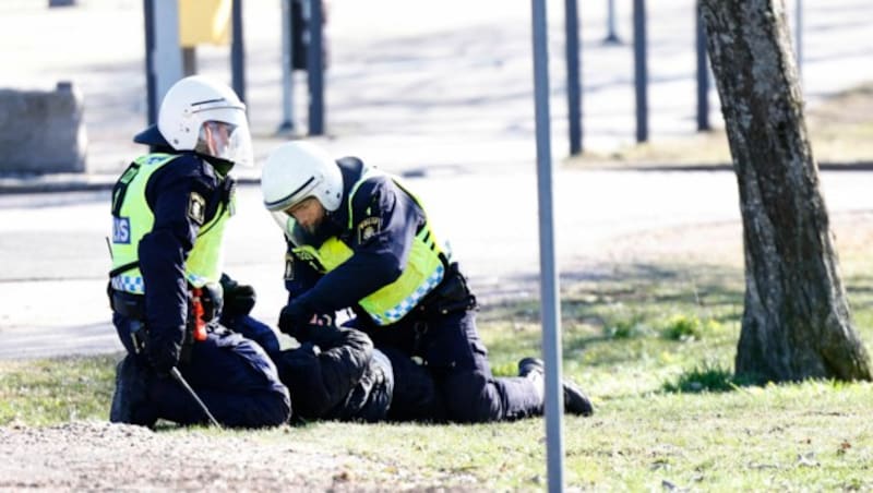 Polizisten verhaften einen Demonstranten in Norrköping (Bild: AFP)