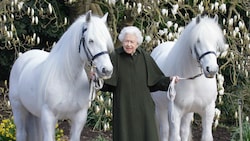 Queen Elizabeth II. steht zwischen den schneeweißen Ponys „Bybeck Katie“ und „Bybeck Nightingale“. (Bild: APA/Henry Dallal/ROYAL WINDSOR HORSE SHOW/AFP)