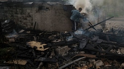 Ein Mann versucht nach einem russischen Bombenangriff auf ein Wohnviertel in Charkiw ein Feuer zu löschen. (Bild: AP)