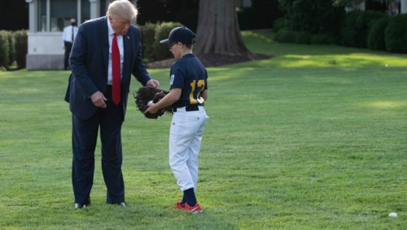 Ex-US-Präsident Donald Trump während eines Baseballevents mit einem Buben. (Bild: APA/AFP/JIM WATSON)