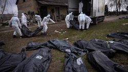 Freiwillige verladen Leichen aus einem Massengrab in Butscha auf diesem Foto vom 12. April zur späteren forensischen Untersuchung auf einen Lastwagen. (Bild: ASSOCIATED PRESS)
