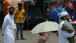 Menschen schützen sich mit Schirmen vor der Hitze. (Bild: AP)