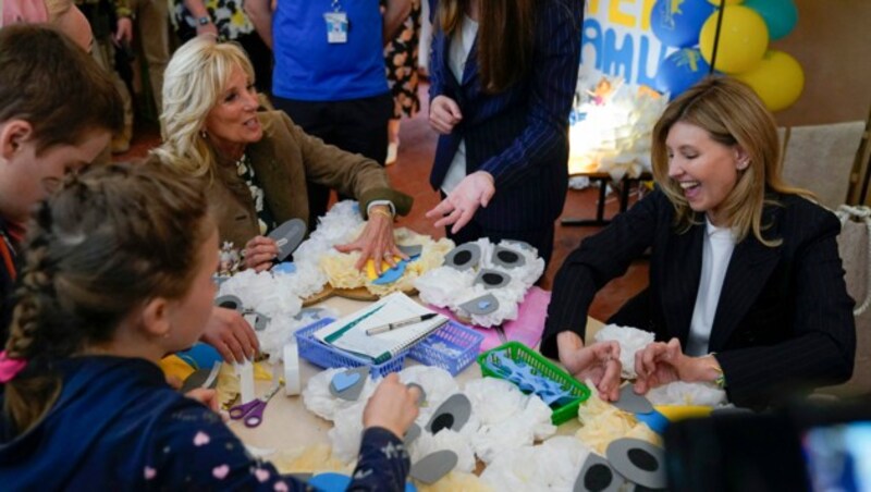 US-First Lady Jill Biden und die ukrainische Präsidentengattin Olena Zelenska schließen sich einer Gruppe von Kindern an, die in der Schule Bären aus Seidenpapier als Muttertagsgeschenke basteln. (Bild: APA/AFP/POOL/Susan Walsh)