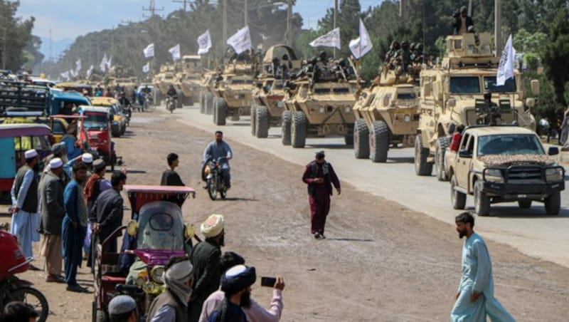 Taliban-Kämpfer in gepanzerten Fahrzeugen bei einer militärischen Straßenparade in Herat (Bild: AFP)