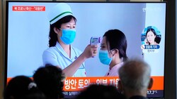 Passanten im südkoreanischen Seoul verfolgen auf einem Fernsehbildschirm einen Nachrichtenbericht über den Covid-19-Ausbruch im benachbarten Nordkorea. (Bild: AP)