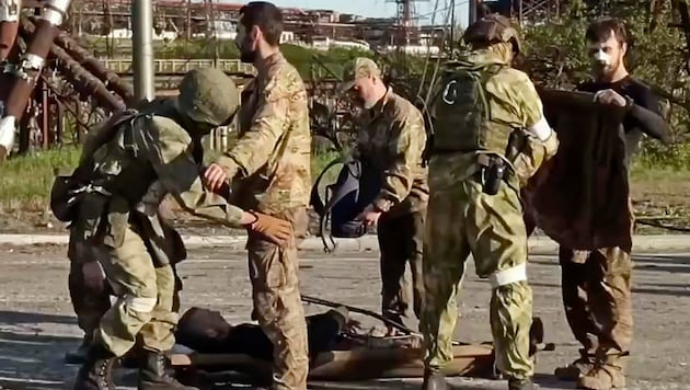 Unmittelbar nach dem Verlassen des Stahlwerks von Mariupol wurden die ukrainischen Kämpfer gefangen genommen und von russischen Soldaten durchsucht. (Bild: AP)