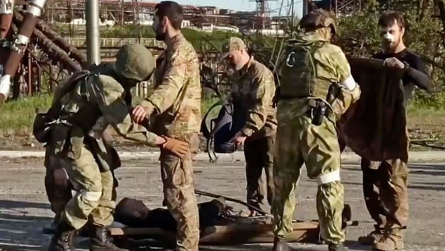 Unmittelbar nach dem Verlassen des Stahlwerks von Mariupol wurden die ukrainischen Kämpfer empfangen und von russischen Soldaten durchsucht. (Bild: AP)