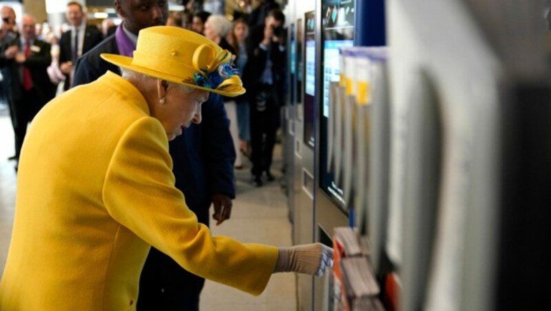 Queen Elizabeth II. drückt sich das erste Ticket für die neue Elizabeth LIne aus dem Automaten. (Bild: APA/Andrew Matthews/AP)