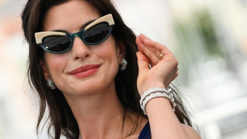 Süßes Accessoire: Anne Hathaway trug zu ihrem sexy Mini-Dress eine Sonnenbrille im Cat-Eye-Stil. (Bild: AFP)