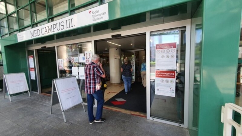 Eingang zum Med Campus III mit Zutritts- und Besuchsregeln auf Plakaten (Bild: Werner Pöchinger)