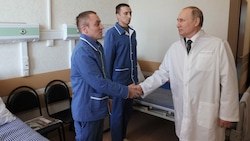 Zwei Soldaten, die während des russischen Angriffes verwundet wurden, schütteln Putin die Hand. (Bild: APA/AFP/SPUTNIK/Mikhail Metzel)
