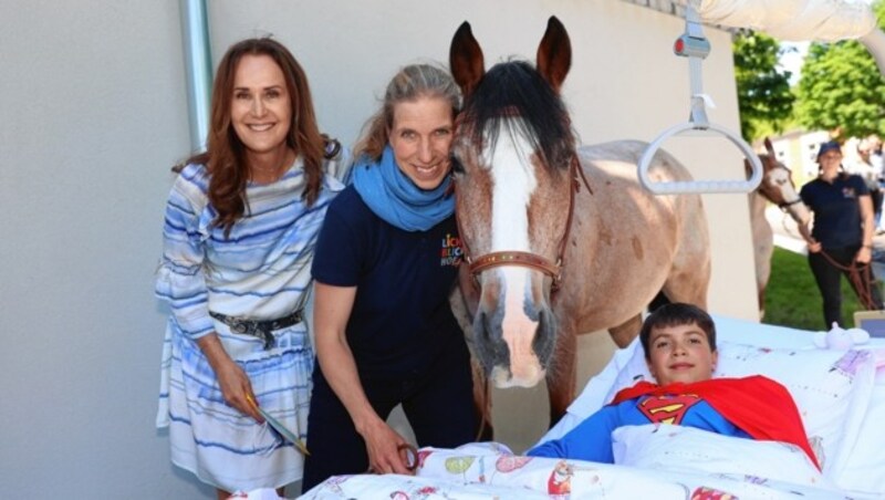 Unterstützerin Maggie Entenfellner mit Roswitha Zink und Pferd Korumi an der Seite des kleinen „Superman“ Timo (Bild: Tomschi Peter)