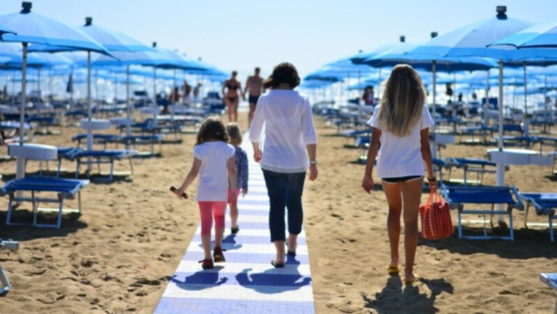 Laut einer Spectra-Umfrage machten die Österreicherinnen und Österreicher in diesem Jahr vor allem einen Badeurlaub (im Bild: Strand in Lignano). (Bild: ©corradobarattaphotos - stock.adobe.com)