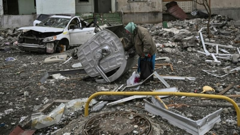 Eine ältere Frau steht inmitten von Trümmern in der Nähe eines beschädigten Wohnhauses in einem Frontbezirk von Charkiw. (Bild: AFP)