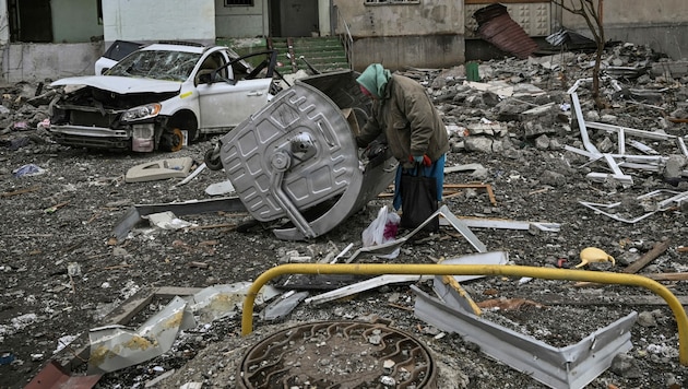 Eine ältere Frau steht inmitten von Trümmern in der Nähe eines beschädigten Wohnhauses in einem Frontbezirk von Charkiw. (Bild: AFP)