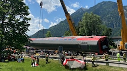 Einen Tag nach dem Zugunglück in Bayern ist die Zahl der Toten auf fünf gestiegen. Ein Kran hilft bei den andauernden Bergungsarbeiten. (Bild: APA/dpa/Sabine Dobel)