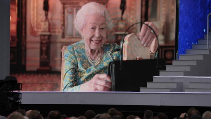 Die Zuschauer sehen einen Film von Königin Elizabeth II. beim Tee mit Paddington Bär auf einer großen Leinwand während der Platinparty vor dem Buckingham Palace in London. In der Szene holt die Queen ein Marmeladen-Sandwich aus ihrer Tasche. Das habe sie immer dabei ... (Bild: Victoria Jones / PA / picturedesk.com)