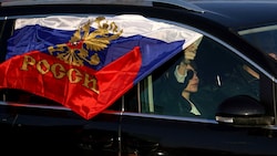 Eine prorussische Kundgebung in Belgrad inklusive russischer Flagge (Bild: APA/AFP/OLIVER BUNIC)