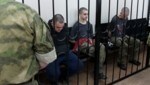 Die beiden britischen Staatsbürger Aiden Aslin (li.) und Shaun Pinner (re.) sowie der Marokkaner Saaudun Brahim (Mitte) sitzen hinter Gittern in einem Gerichtssaal in Donezk. (Bild: ASSOCIATED PRESS)