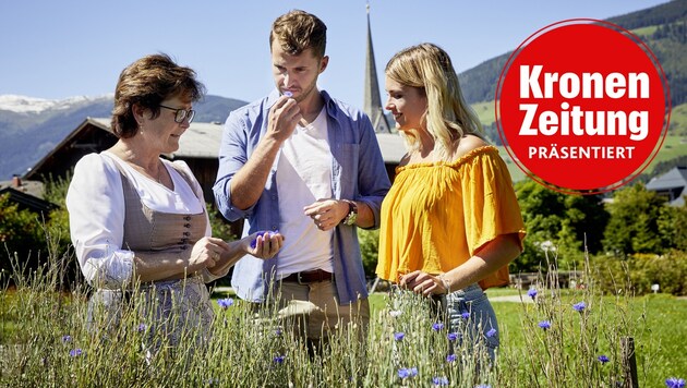 Andrea Rieder vom Hollersbacher Kräutergarten zeigt einem Pärchen ihre Schätze an Kräuter und Blüten. (Bild: Andrea Rieder © SalzburgerLand Tourismus, Krone KREATIV)